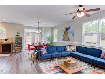 Bright living room featuring a comfortable blue sectional, colorful rug, and an abundance of natural light at 610 Chalcedony Ct, Durham, NC 27703