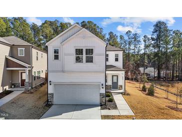 Charming two-story home with a modern white exterior, complemented by a spacious driveway and manicured lawn at 1107 Depot Dr, Durham, NC 27703