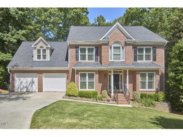 Two-story brick home with a well-manicured lawn and attached two-car garage at 407 Crickentree Dr, Cary, NC 27518