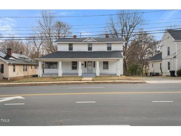 Charming two-story home with a welcoming front porch, mature trees, and classic architectural details at 512 S Mebane St, Burlington, NC 27215