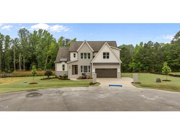 Beautiful two-story home with a manicured lawn, a two-car garage, and a gray and white facade at 5705 Flowery Meadow Ct, Wake Forest, NC 27587