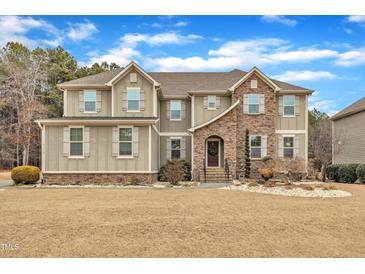 Stunning two-story home boasts stone accents, complemented by a lush front yard, and a welcoming entrance at 6509 Sunset Manor Dr, Wake Forest, NC 27587