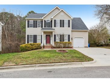 Charming two-story home featuring a well-manicured lawn, complemented by a red front door and black shutters at 8409 Astwell Ct, Raleigh, NC 27615
