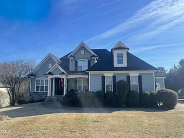 Charming two-story home with detailed trim, black shutters, and a manicured front lawn at 8528 Mangum Hollow Dr, Wake Forest, NC 27587