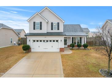 Charming two-story home with a two car garage, manicured lawn, and inviting front porch at 206 Crane Way, Bunnlevel, NC 28323