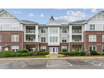 Beautiful condo building with brick and gray siding, balconies, landscaping, and ample parking at 232 Eyam Hall Ln, Apex, NC 27502
