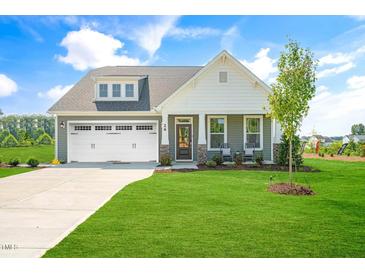 Charming home with a well-manicured lawn, a two-car garage, and stylish architectural details at 26 Kitty Branch Way, Smithfield, NC 27577