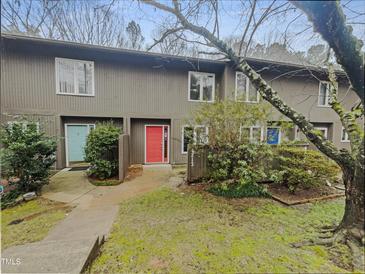 Inviting townhouse exterior with a colorful entrance door and well-maintained landscaping at 4213 Sunscape Ln, Raleigh, NC 27613