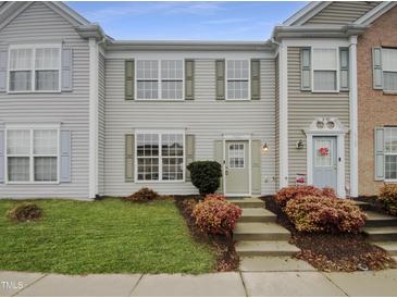 Charming townhouse with manicured lawn, colorful bushes, and inviting light green front door at 5107 Tomasita Ct, Raleigh, NC 27616