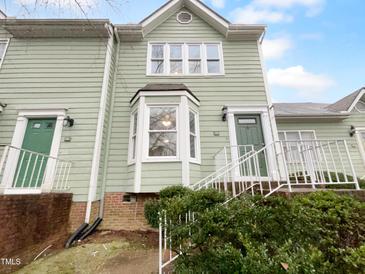 Charming multi-story townhouse with light green siding and updated windows at 516 Caprice Ct, Raleigh, NC 27606