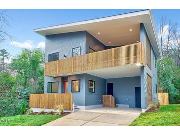 Modern home featuring blue siding, sleek lines, a second-story deck, and inviting curb appeal at 1604 Malta Ave, Raleigh, NC 27610