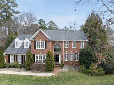 Traditional red brick home featuring a manicured lawn, classic shutters, and a welcoming front entrance at 204 Brittany Pl, Cary, NC 27511