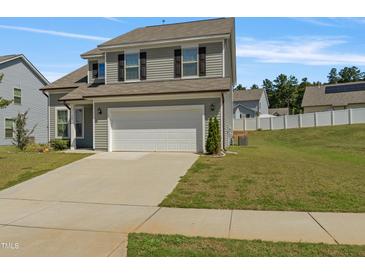Charming two-story home with gray siding, black shutters, a two-car garage, and a well-manicured lawn at 50 Fontaine Dr, Franklinton, NC 27525