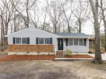 Charming single-story home featuring brick accents, neutral siding, and mature trees at 512 Trail Of Merlin, Garner, NC 27529