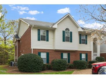 Charming townhouse with brick and siding, showcasing green shutters and manicured landscaping at 521 Renshaw Ct, Cary, NC 27518