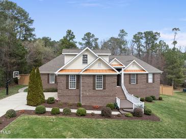 Charming brick home with a manicured lawn, tasteful landscaping, and a welcoming front porch at 6 Kersey Ct, Durham, NC 27713