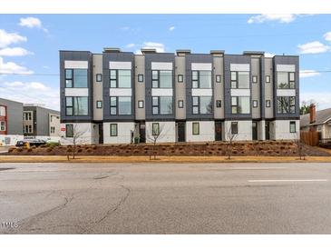 Modern townhomes feature sleek lines, large windows, and neutral color palette, with professionally landscaped front yards at 712 E Edenton St # 102, Raleigh, NC 27601