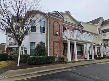 Beautiful townhouse with a red brick facade, white columns, and an open balcony at 10420 Sablewood Drive Dr # 102, Raleigh, NC 27617