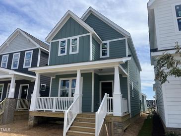 Charming two-story home featuring light green siding, white trim, a cozy front porch, and a welcoming entrance at 1905 Plott Balsam Dr, Wendell, NC 27591