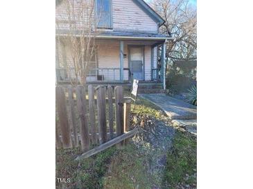 Charming two-story home with covered porch and weathered picket fence at 206 S Goley St, Durham, NC 27701