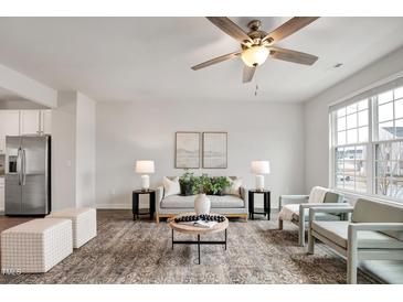 Bright living room with neutral decor, modern furnishings, and a stylish ceiling fan at 240 Amber Acorn Ave, Raleigh, NC 27603