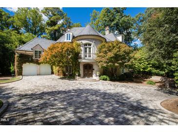 Elegant stone home featuring a turret entry, slate roof, ivy covered walls and brick driveway at 2658 Davis St, Raleigh, NC 27608