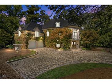 Stunning stone home featuring a circular driveway, ivy covered walls, and a beautiful balcony at 2658 Davis St, Raleigh, NC 27608