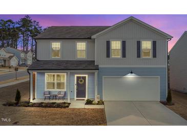 Charming two-story home with a well-maintained lawn, a welcoming front porch, and an attached two-car garage at 3512 Dragonfly River Ct, Raleigh, NC 27604