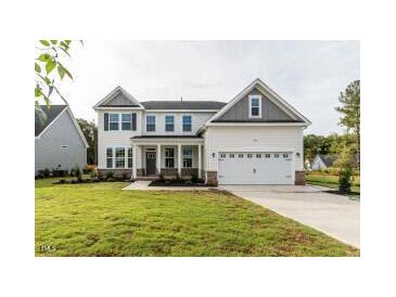 Inviting two-story home with a manicured lawn, attached two car garage, and classic architectural details at 3529 Bailey Lk Dr, Fuquay Varina, NC 27526