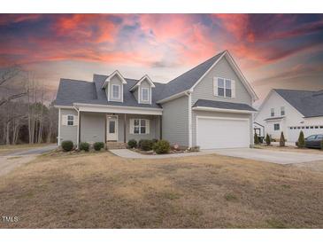 Charming two-story home with gray siding and an attached two-car garage at sunset at 375 Thomas Arnold Rd, Zebulon, NC 27597