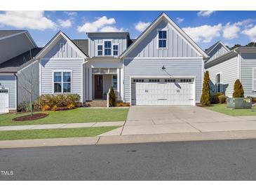 Charming home showcasing light blue siding, a two-car garage, and a well-manicured lawn at 729 Daniel Ridge Rd, Wendell, NC 27591