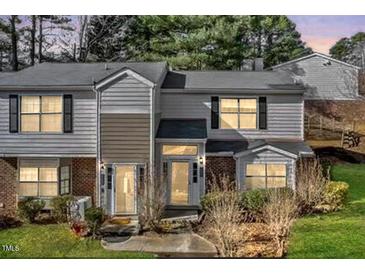 Traditional style townhome with neutral siding, black shutters, and manicured lawn at 7712 Falcon Rest Cir, Raleigh, NC 27615