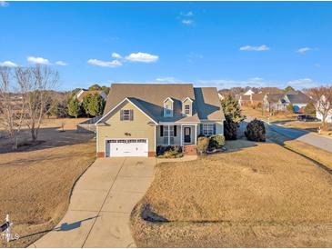 Inviting two-story home featuring a two-car garage,dormers and manicured lawn in a quiet neighborhood at 8116 Hartwood Glen Cir, Willow Springs, NC 27592