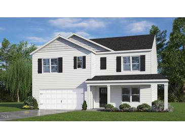 Charming two-story home featuring black shutters, a covered front porch, and a two-car garage at 904 Canis Minor Rd, Wendell, NC 27591
