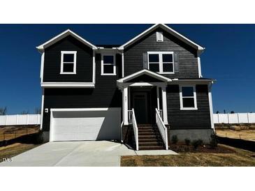 Charming two-story home featuring a spacious garage, covered entry and manicured landscaping at 921 Emmer St, Rolesville, NC 27571
