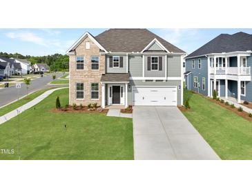 Charming two-story home featuring a two-car garage, well-manicured lawn, and classic architectural details at 15 Nimble Way # 175, Clayton, NC 27520