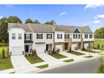 Beautiful new townhomes boast varied exterior colors, front-entry garages, and well-kept landscaping at 341 Church St # 67, Wendell, NC 27591