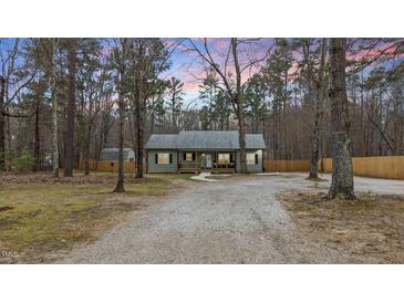 Charming home featuring a gravel driveway and a cozy front porch, surrounded by mature trees at 4082 Old Franklinton Rd, Franklinton, NC 27525