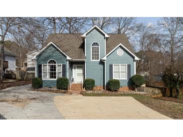 Charming two-story home with a blue exterior, well-manicured landscaping, and a concrete driveway at 886 Drogheda Pl, Wake Forest, NC 27587