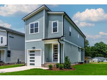Charming two-story home features a modern garage and a stylish front door with visible house number at 136 E End Ave # 4, Durham, NC 27703