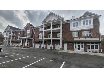 Brick exterior of building with double balconies and ample parking spaces at 1400 Gathering Park Cir # 202, Cary, NC 27519