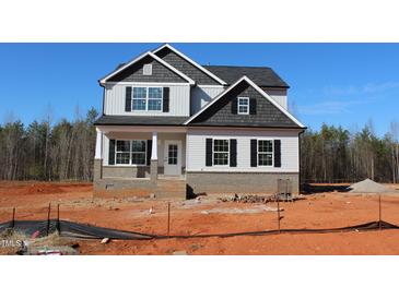 New construction two-story home showing light siding, a brick foundation, and black trim under a bright blue sky at 1415 Reading Ct # 77Kl, Burlington, NC 27217