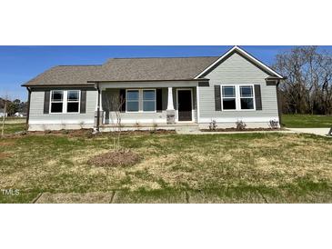 Charming single-story home with gray siding, a well-manicured lawn, and professionally landscaped front yard at 181 Pate Landing Dr, Selma, NC 27576