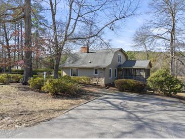 Charming home with a well-maintained front yard, mature trees, and a cozy screened-in porch at 4041 Wendy Ln, Zebulon, NC 27597