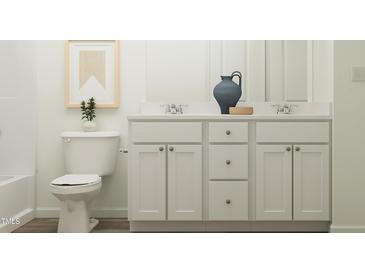 Bright bathroom features double sink vanity, wood-look floors, and framed art for a modern, stylish aesthetic at 406 Queenstown Drive # 24, Kenly, NC 27542