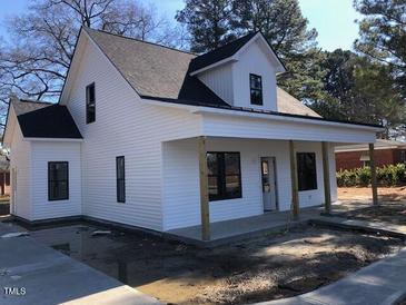 Charming white two-story home with a welcoming front porch and dark-framed windows at 412 N Green St, Selma, NC 27576