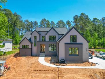 Stunning new two-story home featuring a modern gray color scheme and manicured landscaping at 7412 Wexford Woods Ln, Wake Forest, NC 27587