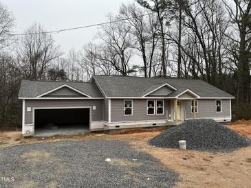 New construction home with attached two-car garage and gray siding at 1516 Bragg St, Sanford, NC 27330