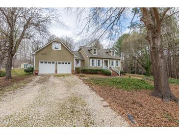 Charming home featuring a two-car garage and a welcoming front porch, surrounded by mature trees at 2010 Twin Acres Rd, Clayton, NC 27520
