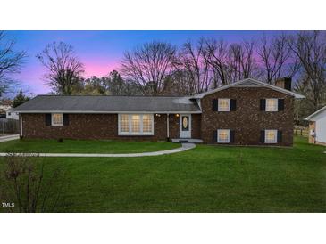Charming brick home with a lush green lawn and a welcoming walkway to the front door at 2605 Sumac Ln, Burlington, NC 27215